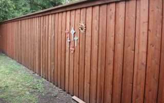 Pre-stained 8-foot board-on-board cedar privacy fence with top cap, trim, and hidden steel posts in Dallas, TX