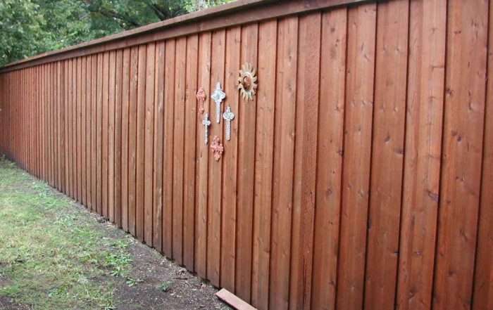 Pre-stained 8-foot board-on-board cedar privacy fence with top cap, trim, and hidden steel posts in Dallas, TX